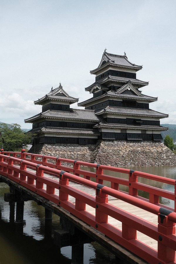 The black castle of Matsumoto with it's iconic red bridge in front. Matsumoto